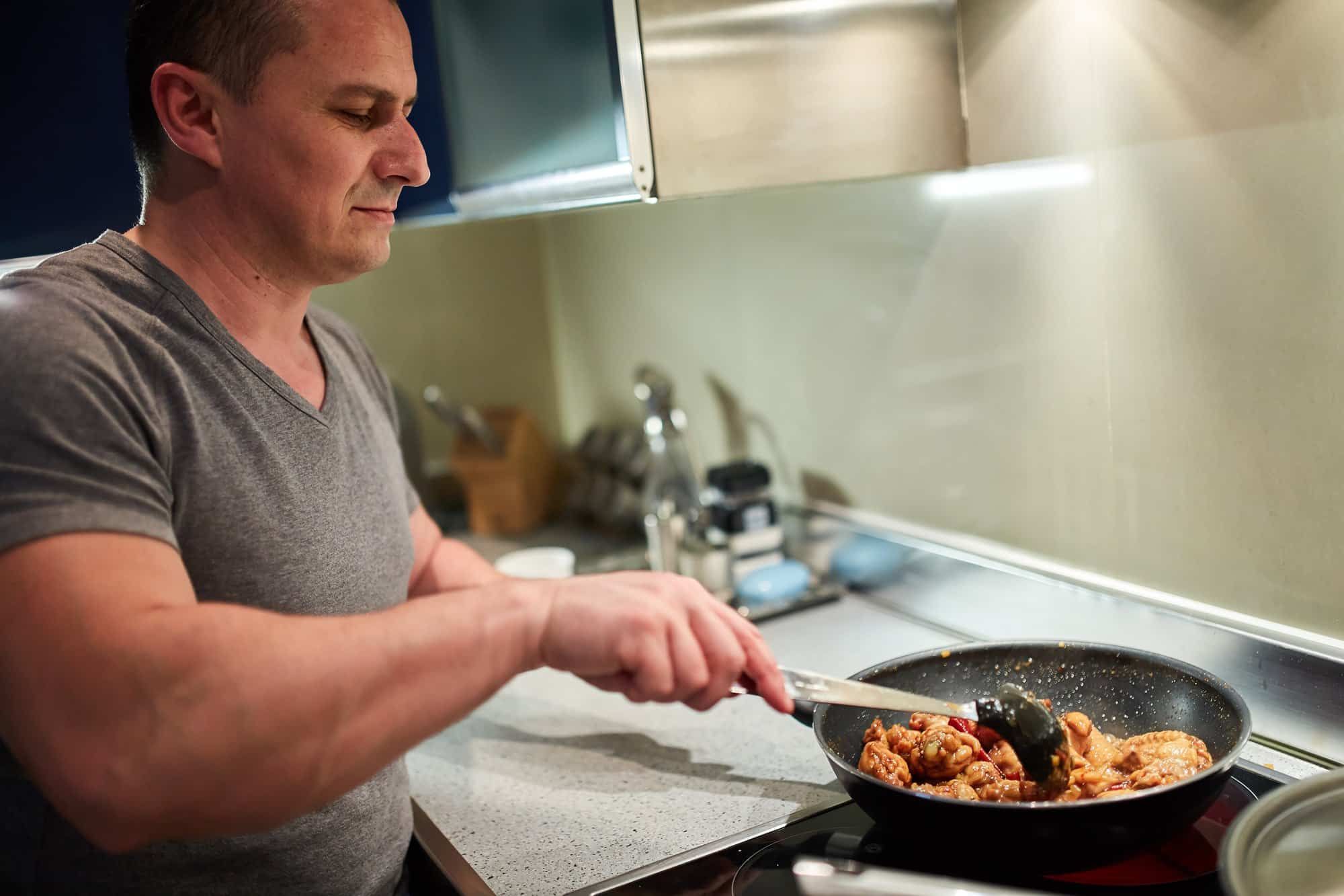 man cooking on stove at home
