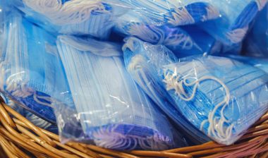 Packs of blue medical face masks lie in a brown basket - sales tax
