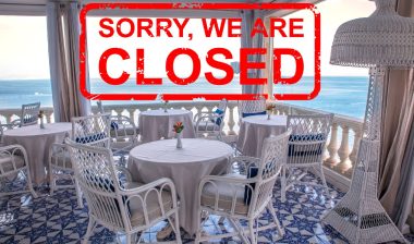 An open-air restaurant by the ocean with a stamp over the photo that reads "sorry, we're closed" in red - bars in Hawaii