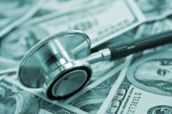 Stethoscope sits on hundred dollar bills