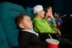 Boys sit in movie theater seats