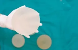 A gloved hand holds a breast implant