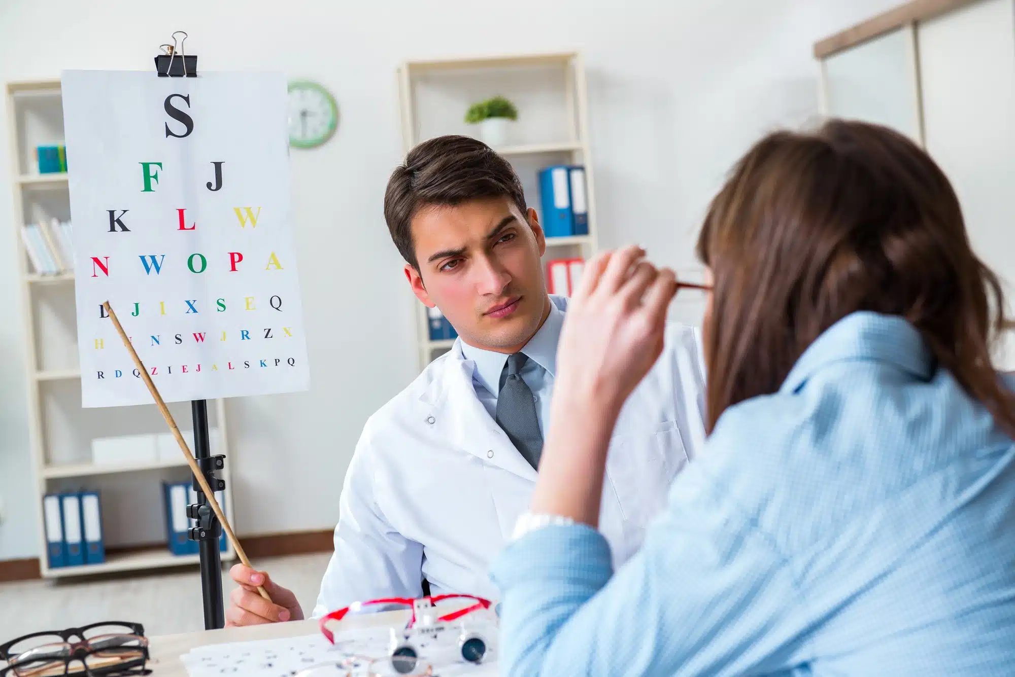 Male eye doctor and female patient receiving exam