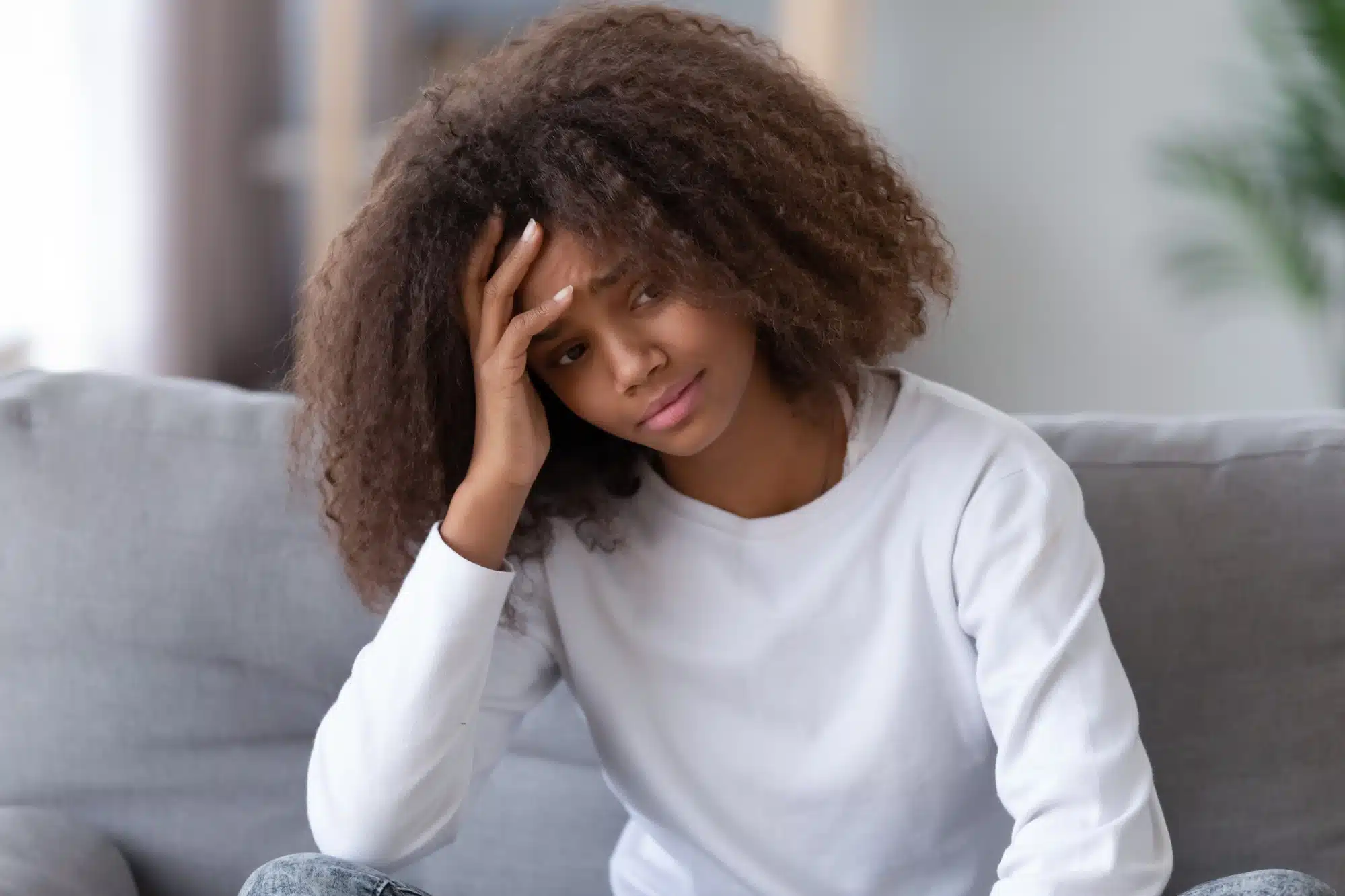 Sad teen girl sits on couch