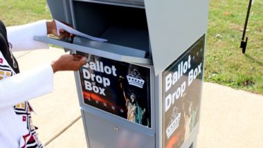 A voter drops a ballot in a drop box - Georgia voters