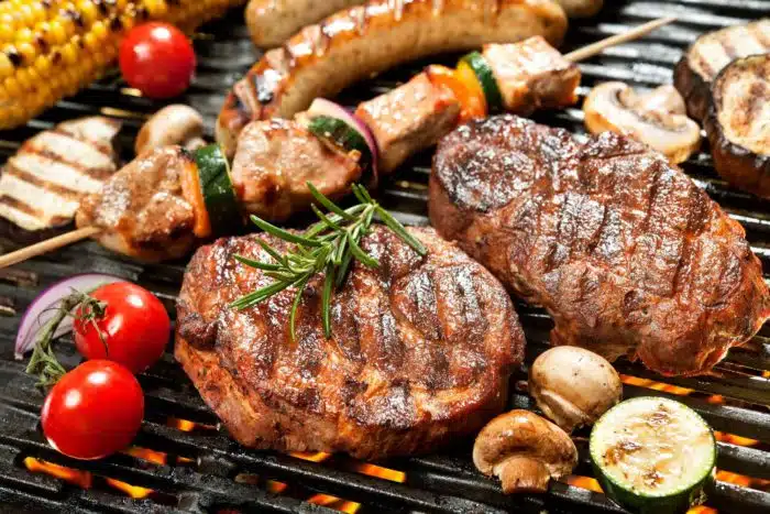 BBQ grill loaded with meat and veggies seasoned with Flavor God products