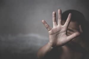 A young child holds their palm toward the camera while hiding their face - Boys and Girls Club of America