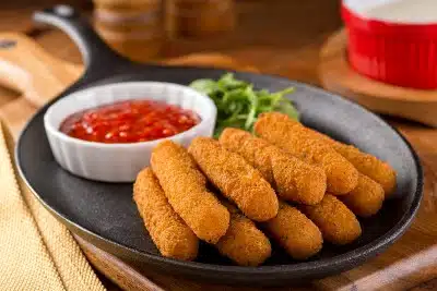Mozzarella sticks on a cast-iron pan with marinara sauce - TGI Fridays Mozzarella Sticks