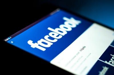 A tablet screen shows an image of the Facebook logo - Facebook location tracking