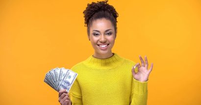 Top Class Actions viewer holding cash from settlement checks