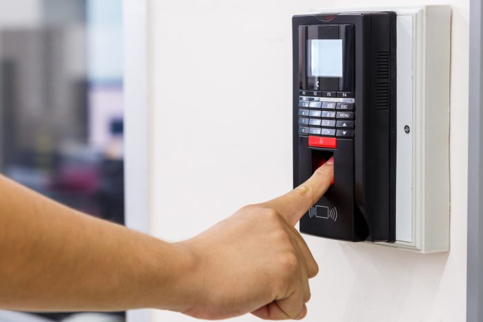 A person scans their finger on a timeclock - Heartland Employment Services