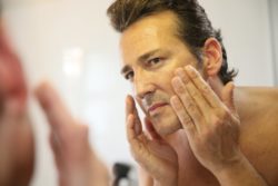 man-putting-on-face-lotion
