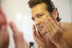 man-putting-on-face-lotion