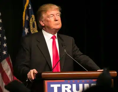 President Trump stands at a podium - health insurance