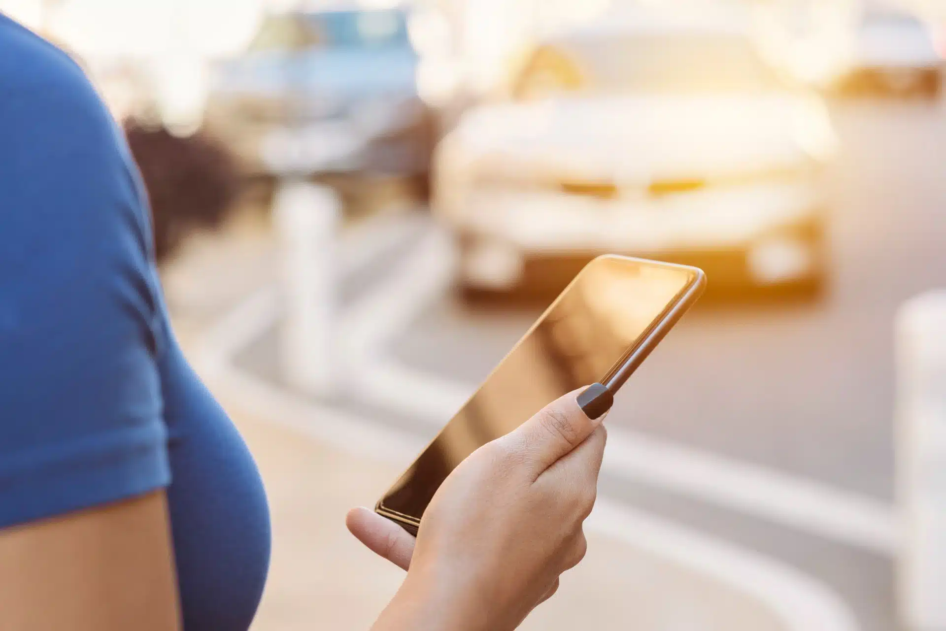 A woman holds a smartphone in a parking lot - Closeup of a woman using a smartphone at night - Uber driver sexual assault