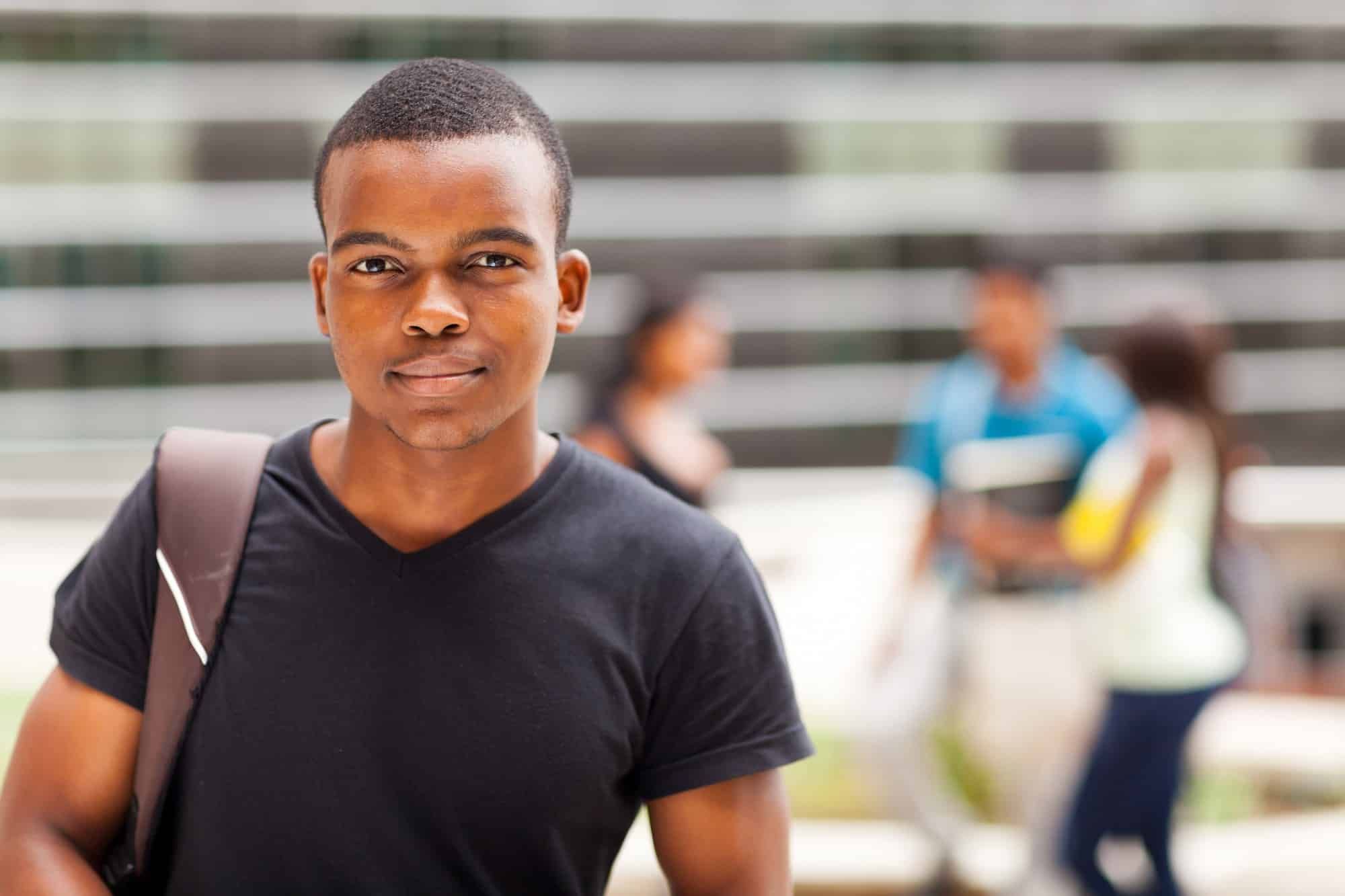 african american student walking across college campus