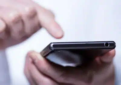 Closeup of a person's hands using a smartphone - data throttling