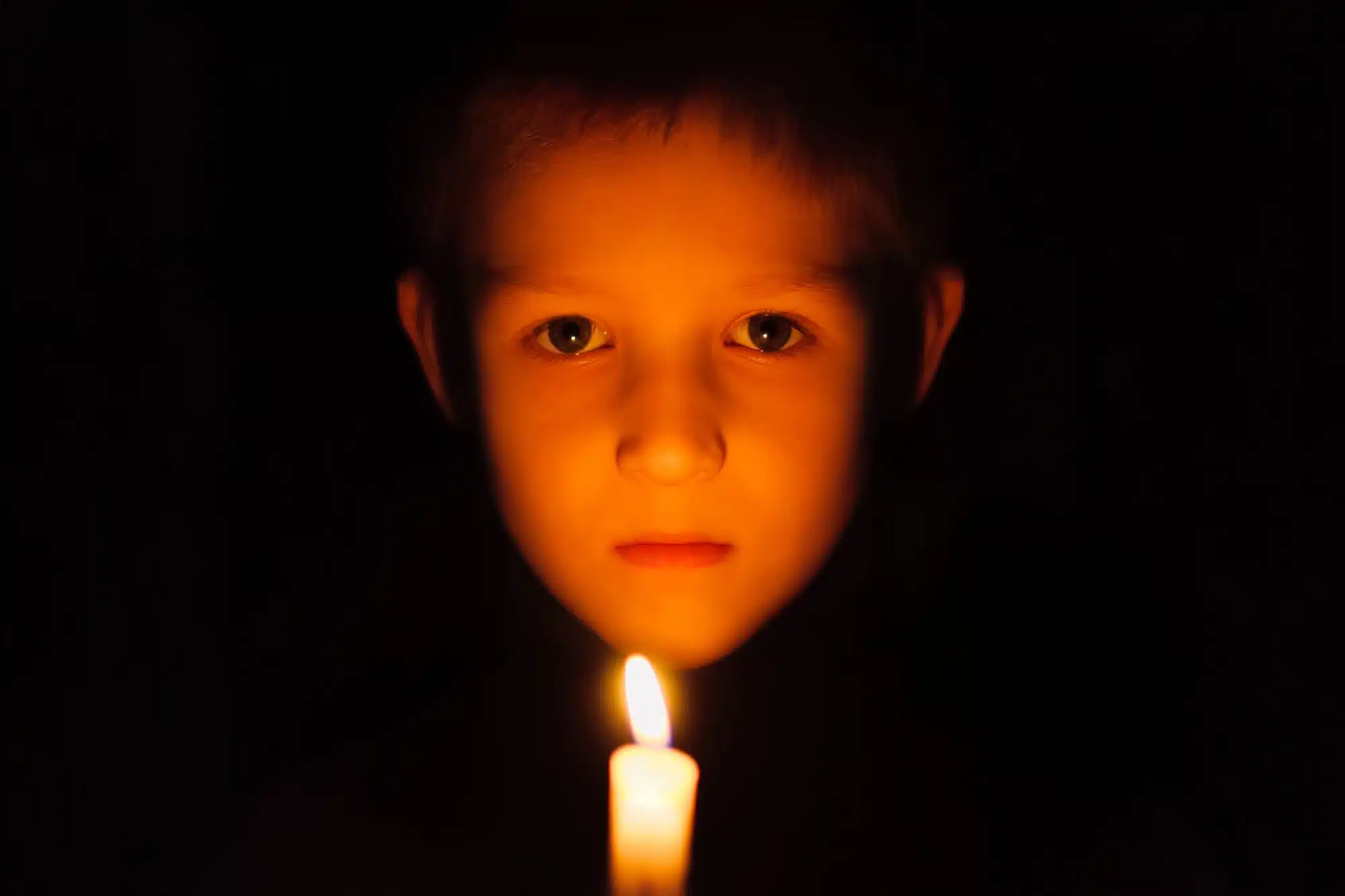 child and candle in power outage
