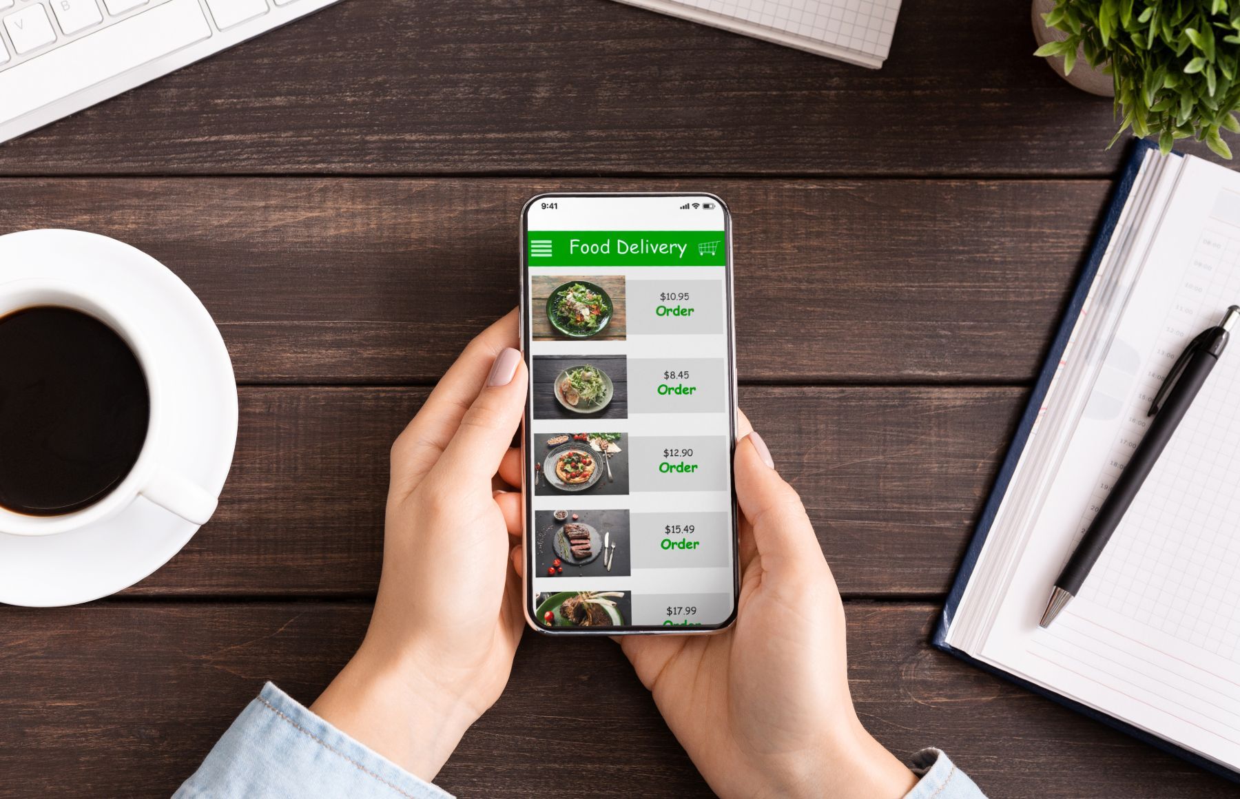 Closeup of a person holding a smartphone showing a food delivery app