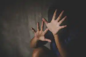 Young girl holds her palms up toward the camera, blocking her face - ymca