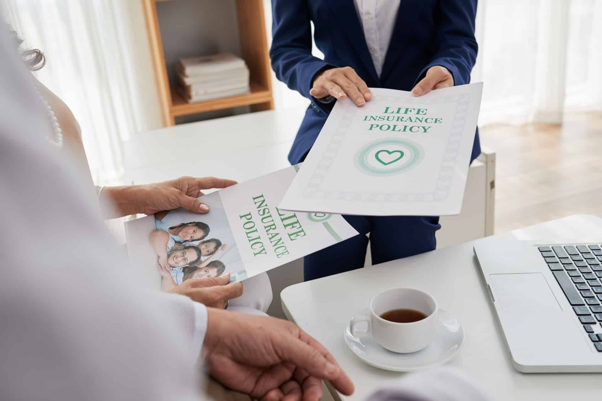 Couple discusses life insurance policy paperwork with a third person - american general life insurance