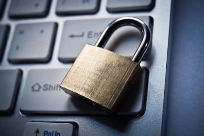 Closed brass-and-chrome padlock on top of computer keyboard - fabfitfun