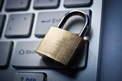 Closed brass-and-chrome padlock on top of computer keyboard - fabfitfun