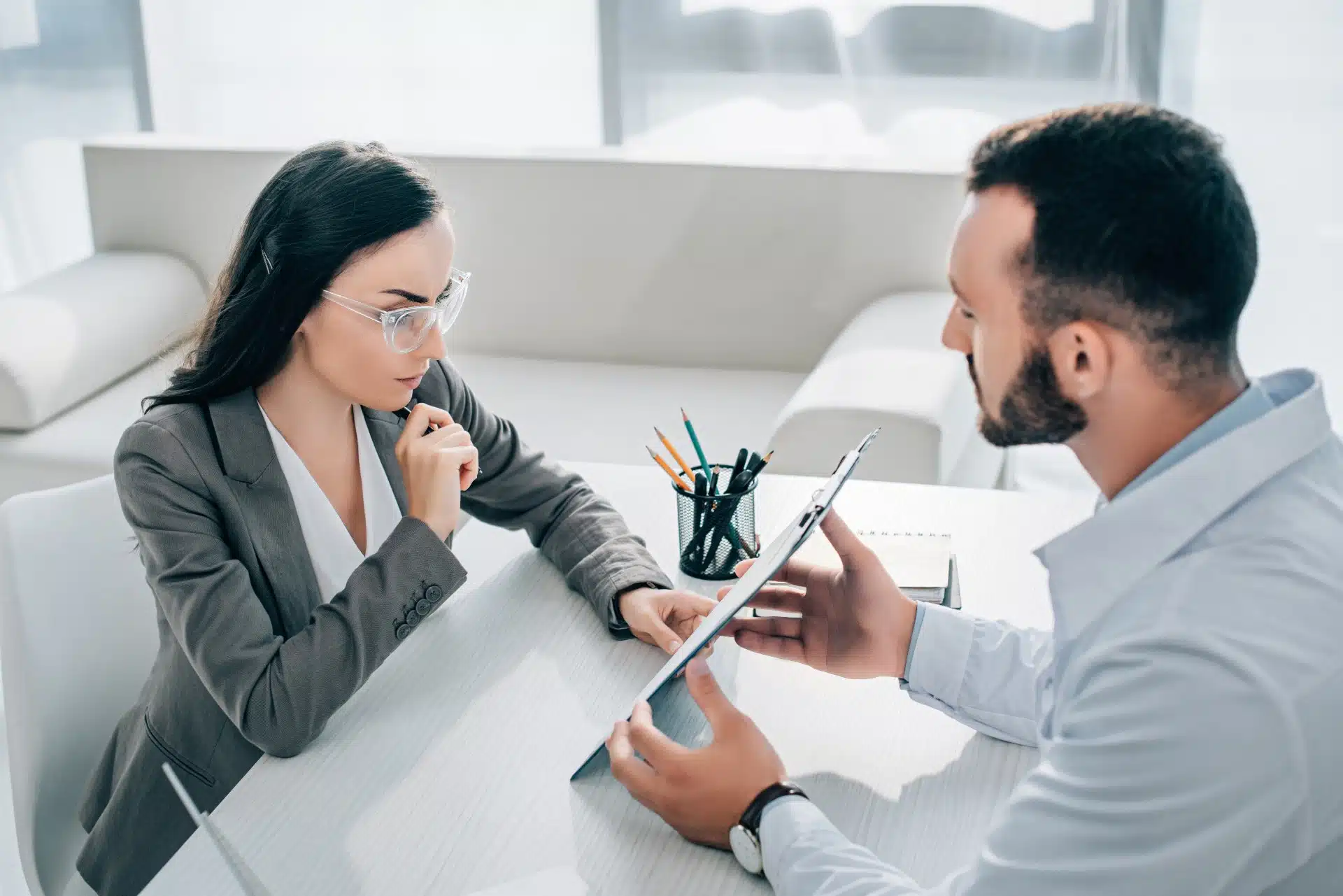 A doctor goes over paperwork with a woman in an office - bcbs settlement