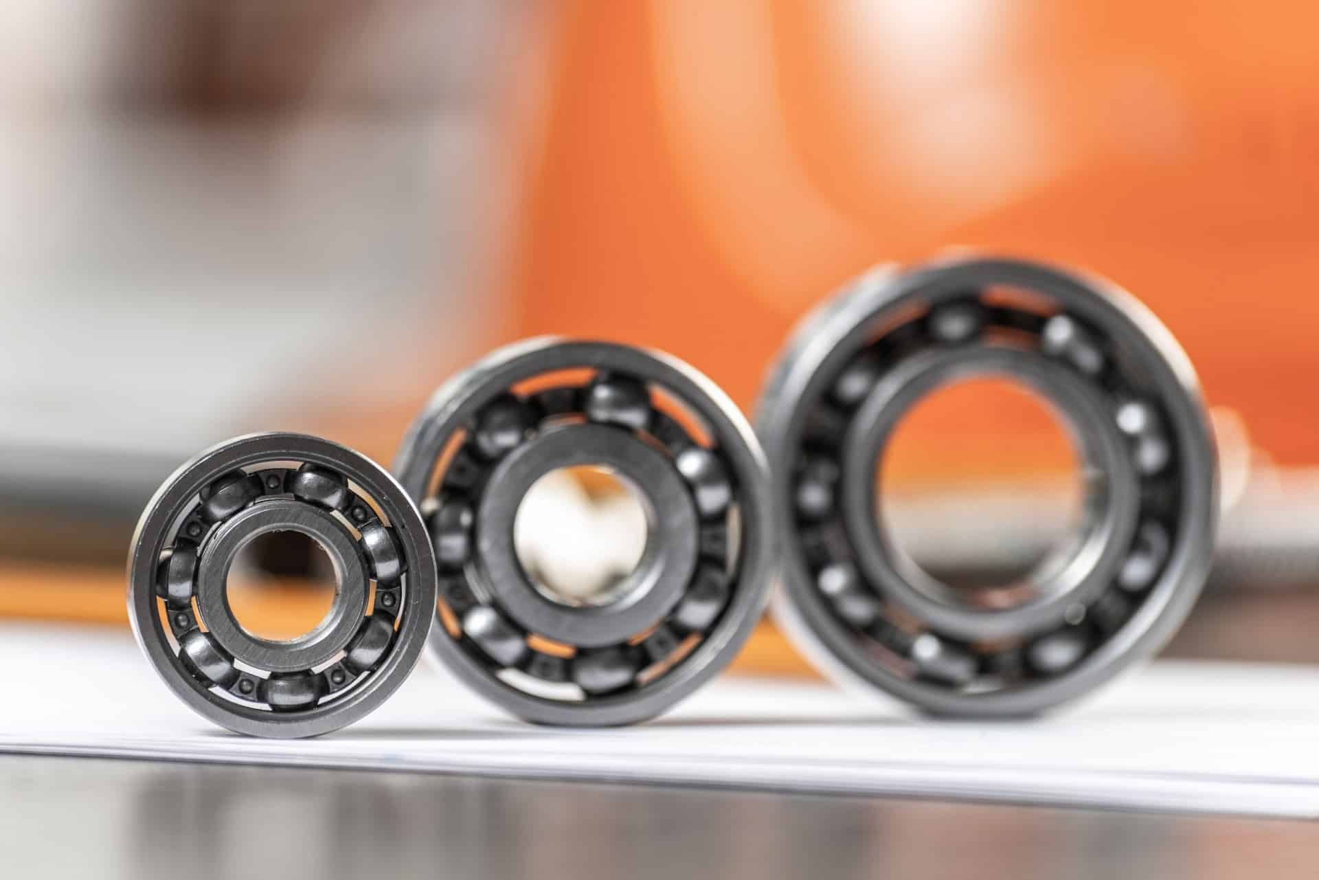 Three sizes of ball bearing sit on end on a table - automotive bearings