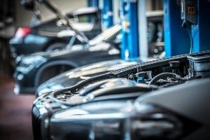 Vehicles with their hoods up are seen in a mechanic's shop - auto recalls