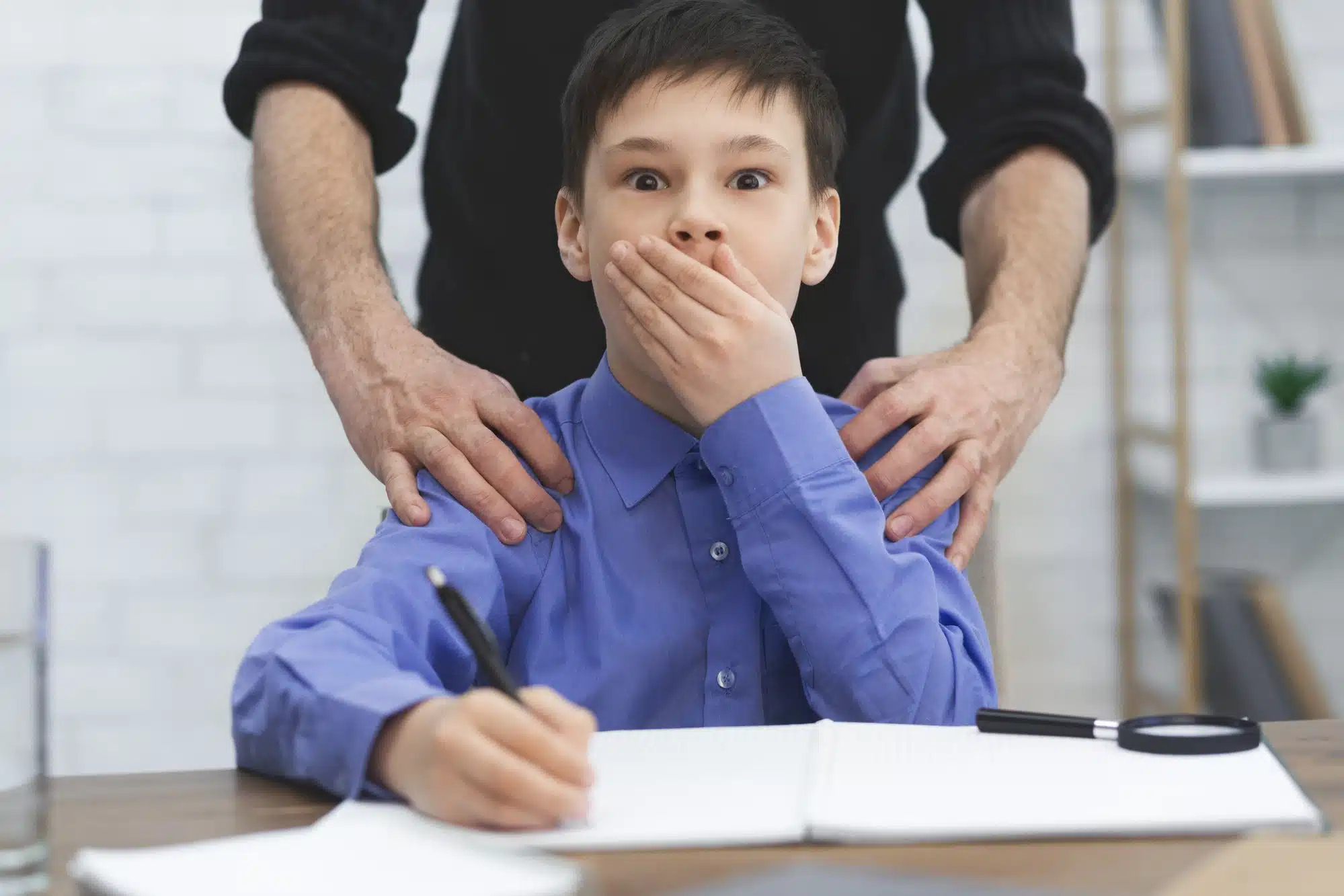 young boy covering mouth, hidden abuse