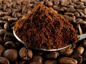 Ground coffee in a spoon on top of coffee beans - maxwell house settlement - clover valley - dollar general