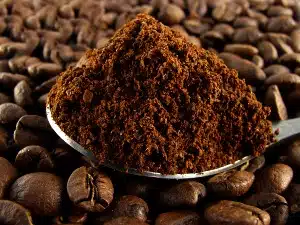 Ground coffee in a spoon on top of coffee beans - maxwell house settlement - clover valley - dollar general