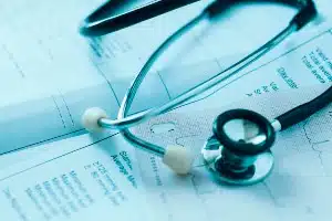 A stethoscope lies on top of health care paperwork - sutter health