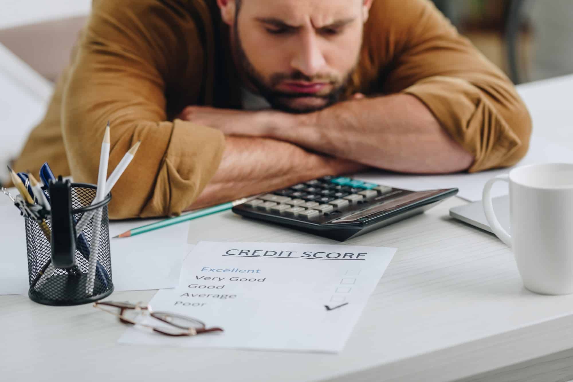 sad man looking at his poor credit rating