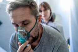 young sick patient with oxygen mask at doctor office