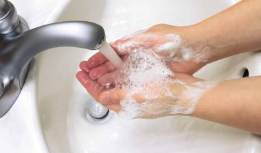 A person washes their hands in a bathroom sink - scent theory