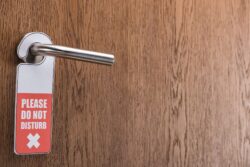 wood hotel door with do not disturb sign