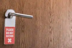 wood hotel door with do not disturb sign