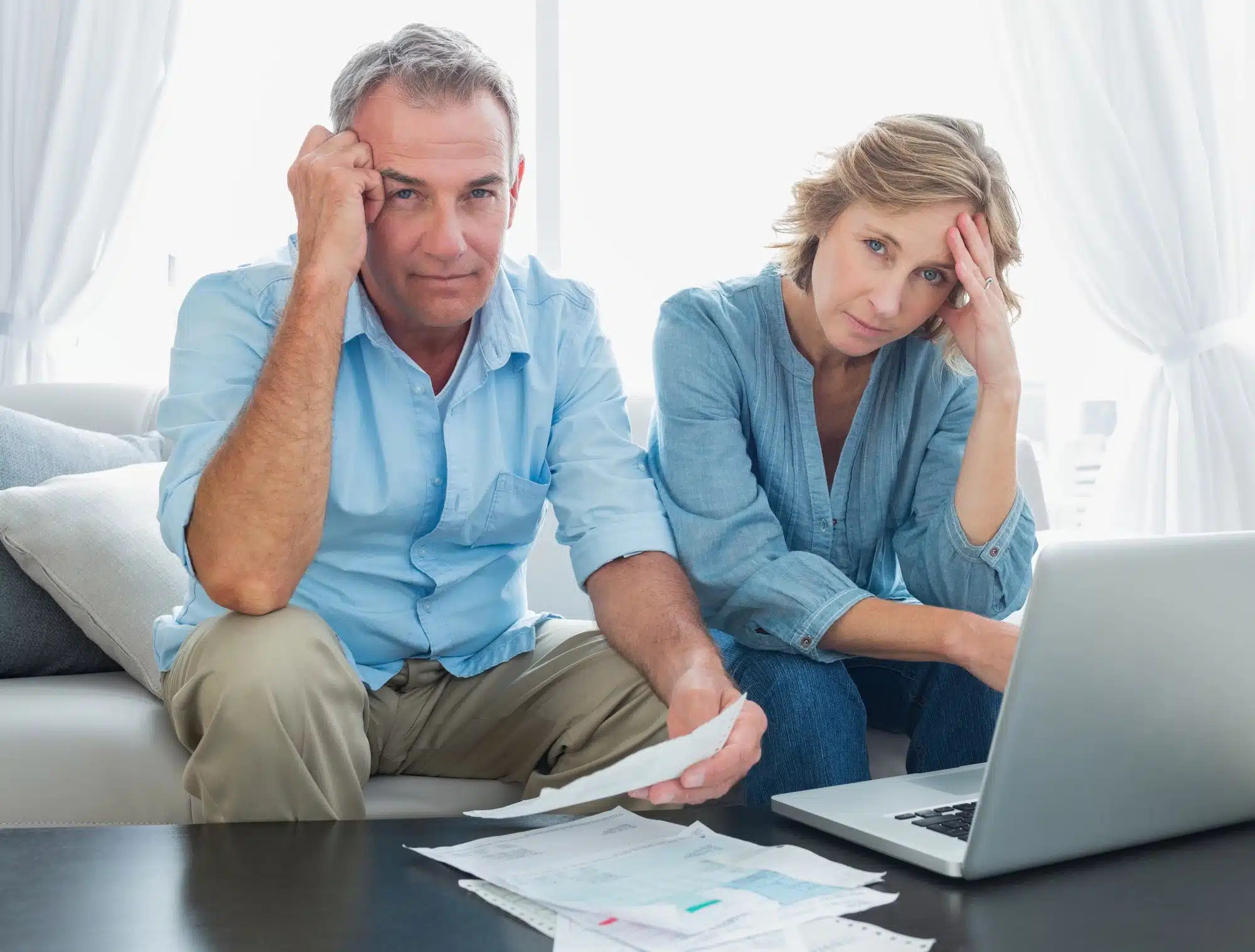 stressed looking couple paying bills online