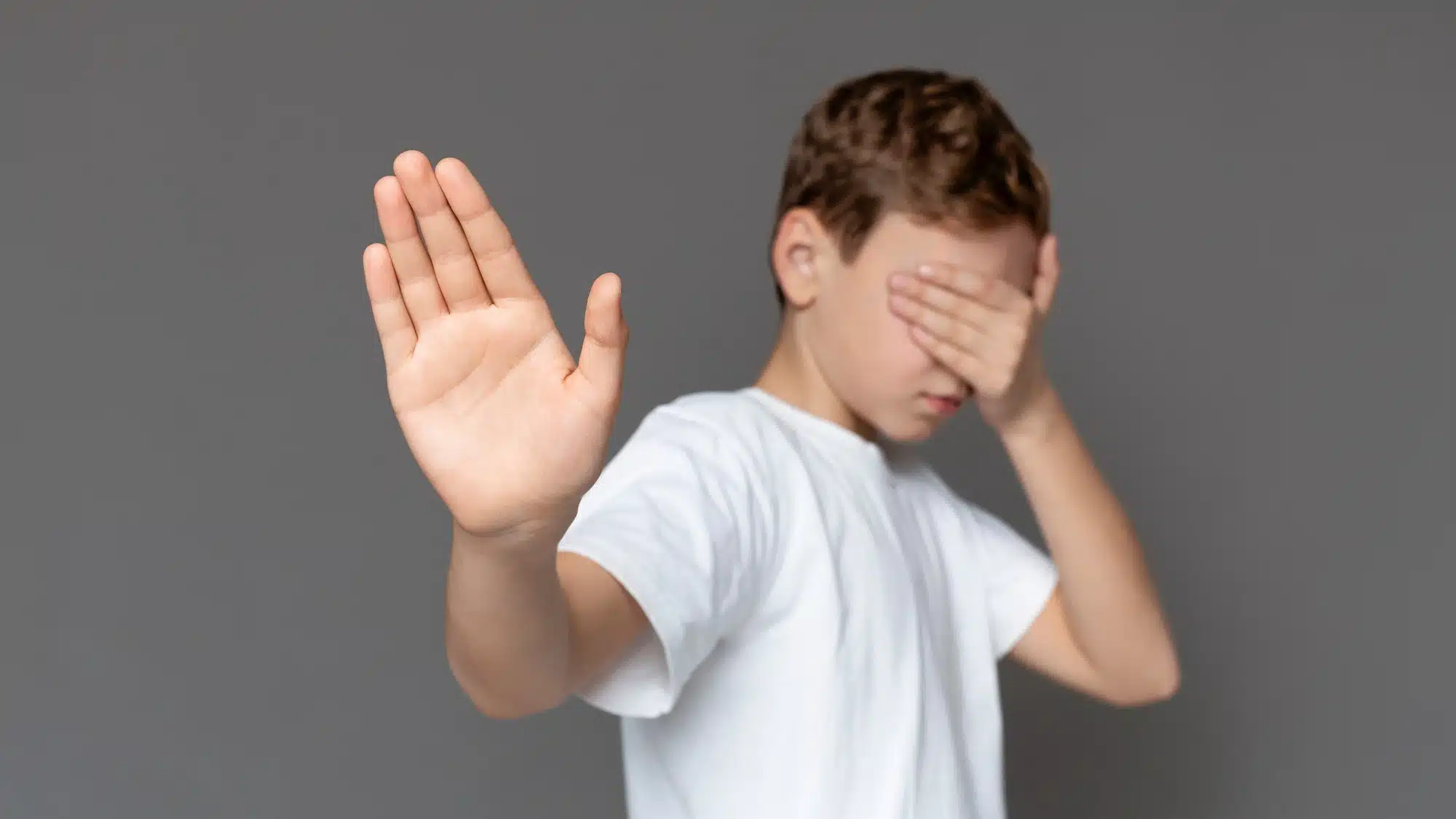 young boy hand held up in stop gesture