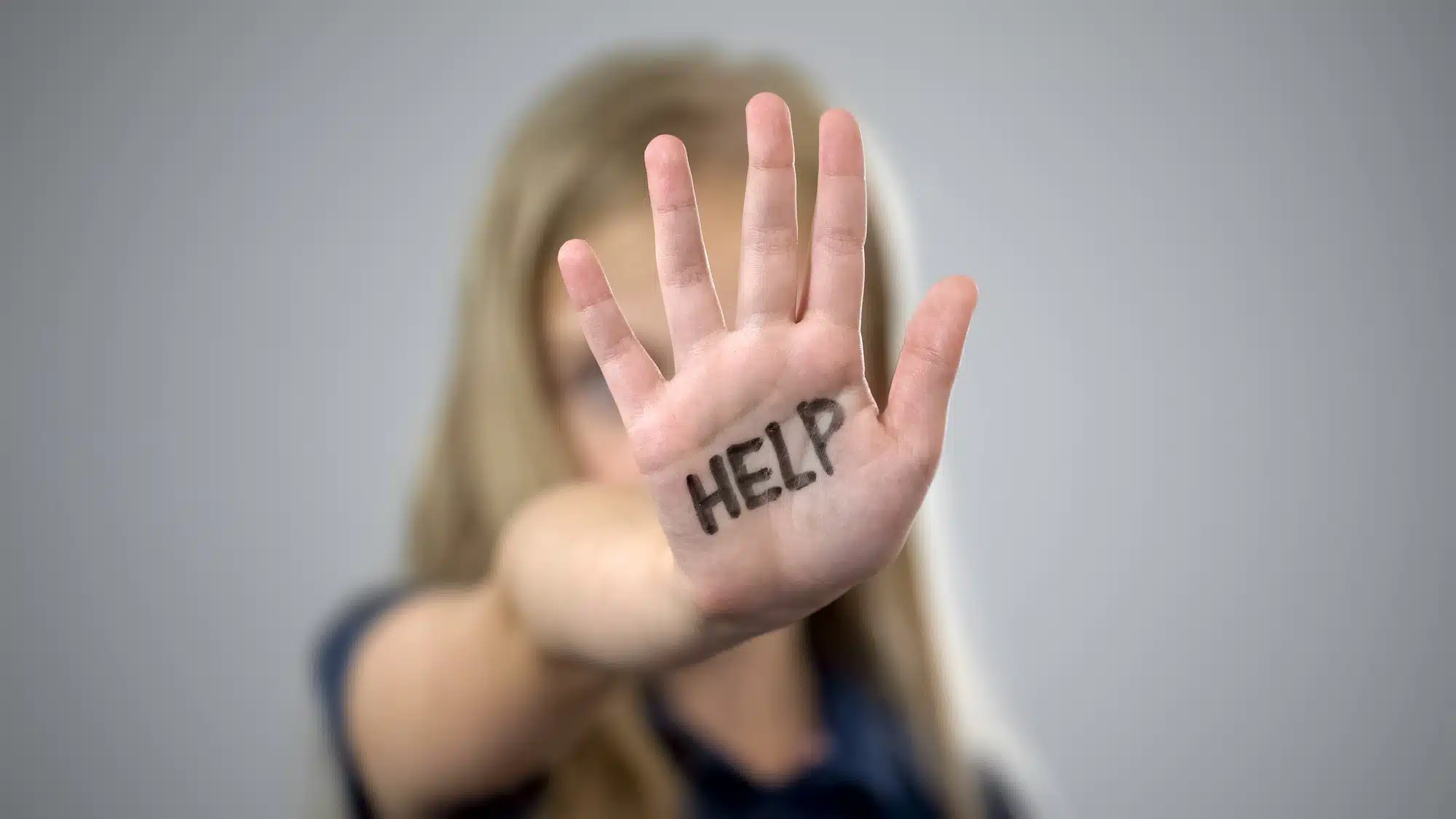 scared girl with HELP on hand, sexual abuse