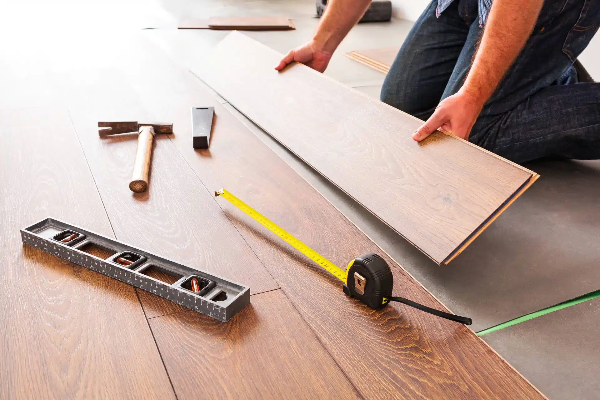 A man installs laminate flooring - Romanoff Floor Covering