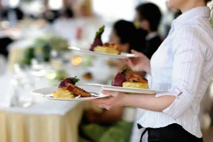 A female restaurant server carries three plates of food - amy ruth's restaurant
