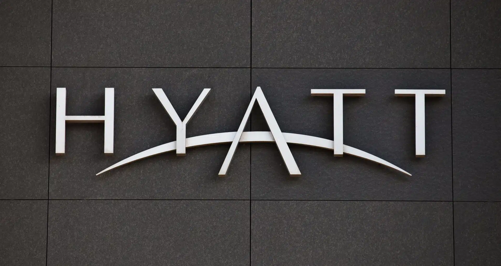 White Hyatt logo on a black wall