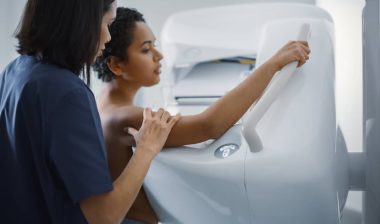 A doctor explaining a mammogram procedure to a patient.