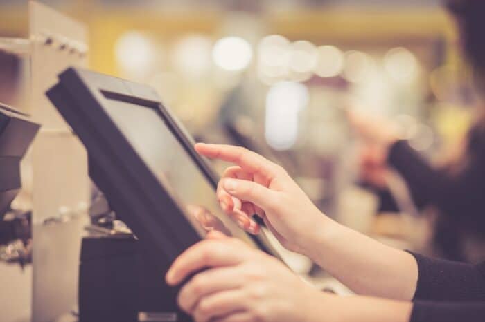 An employee's hands using a point-of-sale system screen - ShopKeep - lightspeed commerce