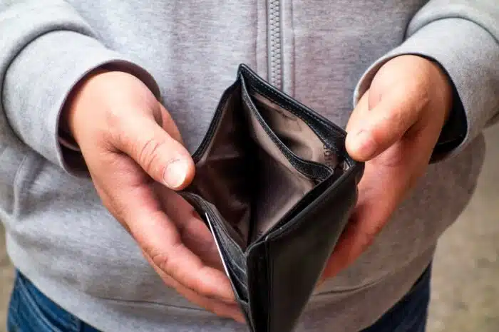 The man has an empty wallet in his hand