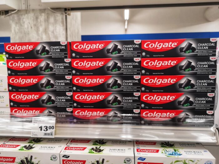 Displayed for sell a new Colgate Charcoal Clean Toothpaste boxed on the supermarket shelf with selective focus.