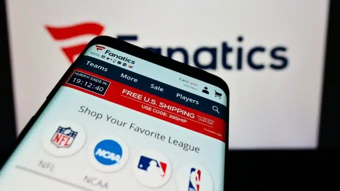 Smartphone with website of online sportswear retailer Fanatics Inc on screen in front of logo Focus on top-left of phone display